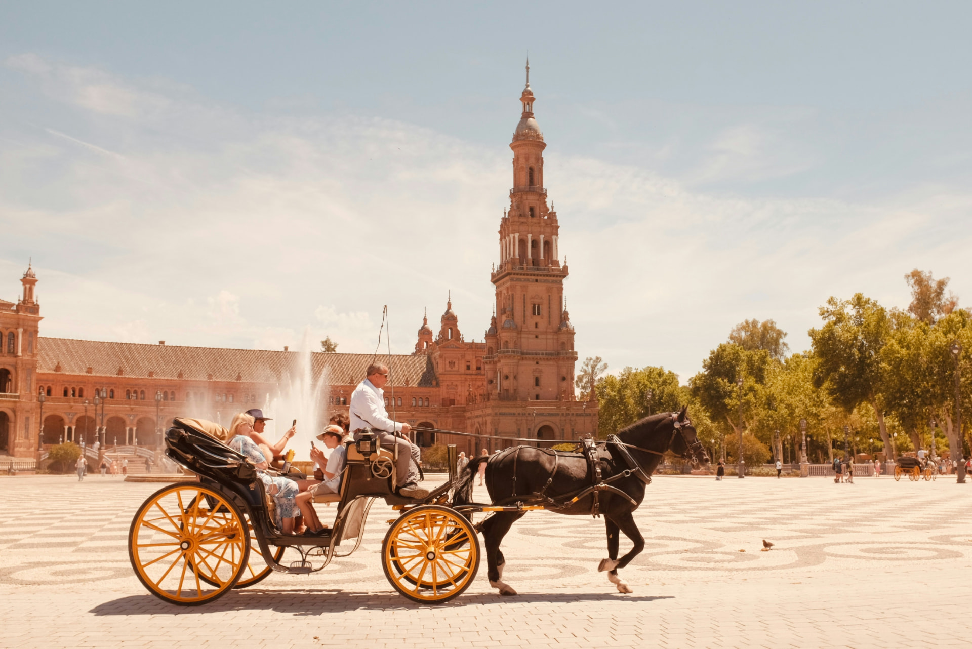 Passengers on their phones in a horse carriage at Plaza de España, Seville